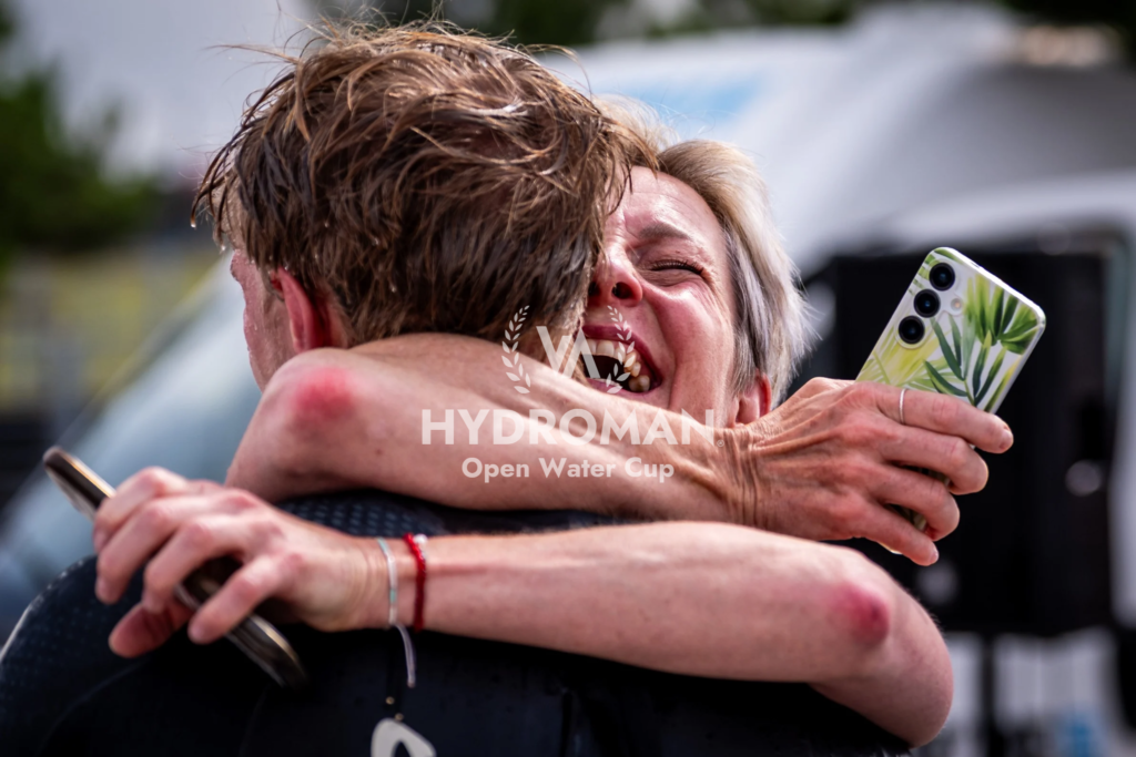 A touching and intimate moment after the HYDROMAN Most Swim race – a swimmer receives a hug after finishing the race. Emotions, joy, pride and success.
